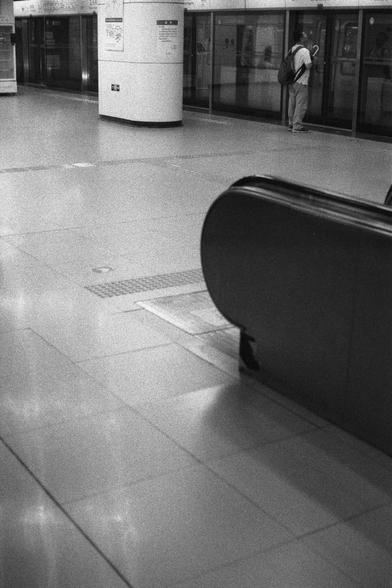 Ilford Delta 3200 (FF)

English
A black and white photograph of the inside of an underground station. A person stands by the side of the platform behind the elevator, waiting.

中文
一张黑白照片, 展示了地铁站的内部.站台边缘站了一个人,在电梯的后方.