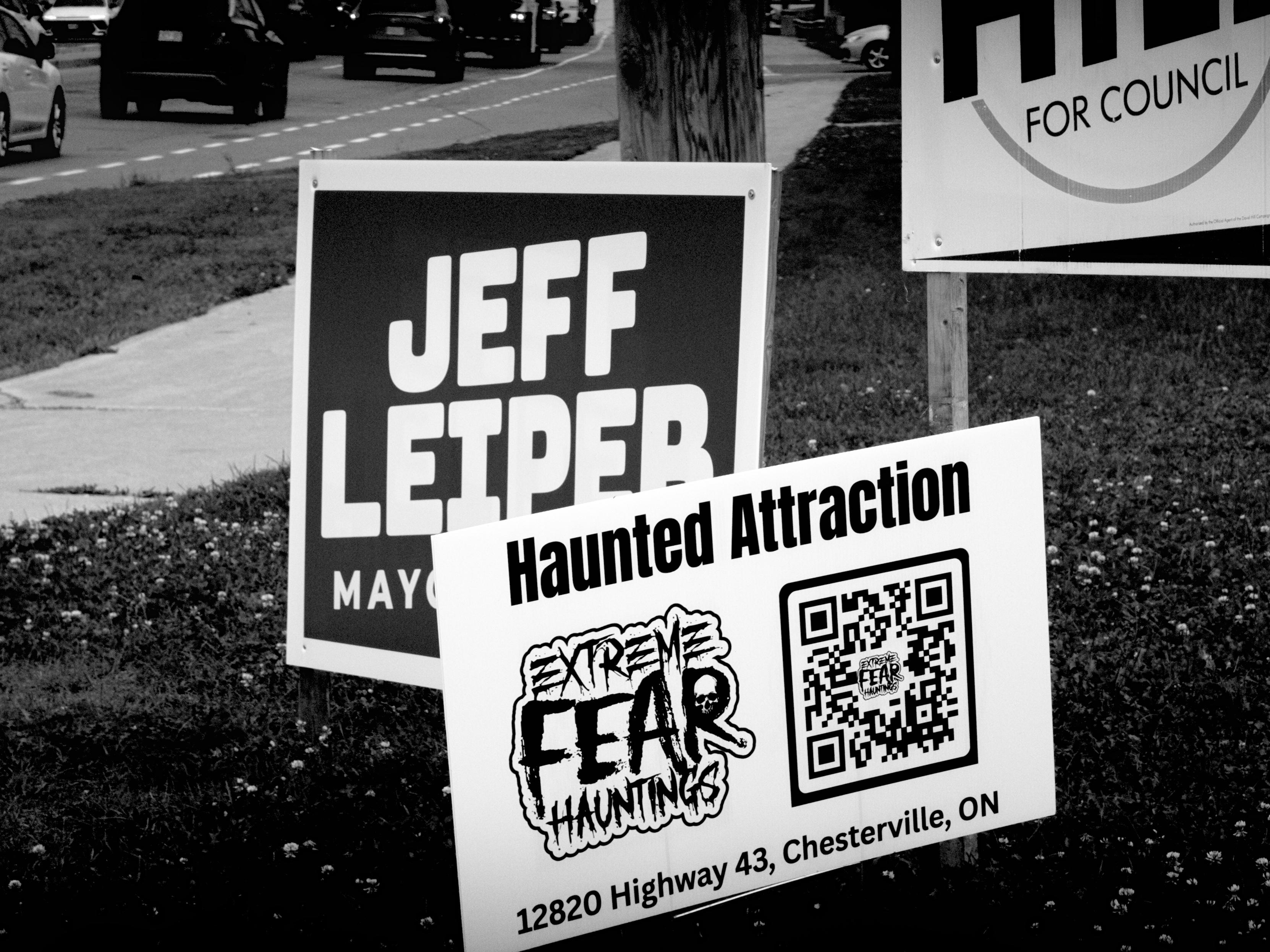 Election signs, and a sign for a "haunted attraction" promising "extreme fear hauntings".