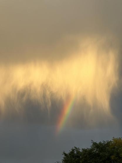 Virga, it’s raining but the air at ground level is so dry it doesn’t each the ground. Sunlight filters thru the clouds to show threads of rain with a stub of a rainbow in the center. September 2026
