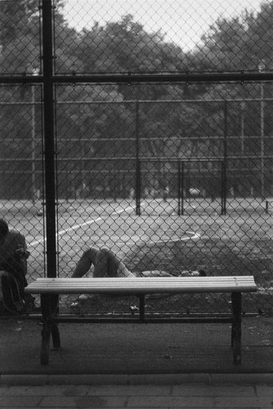 Ilford HP5 Plus 400 (FF)

English
A black and white photograph of a basketball court behind a safety net wire. A person is lying on the ground behind a bench. Someone else sits on the side. Trees can be seen in the background.

中文
一张黑白照片.照片中是一个安全网后面有一个篮球场.一个人躺在地上,前面是一个长椅.边上坐了一个人.背景中有很多树.