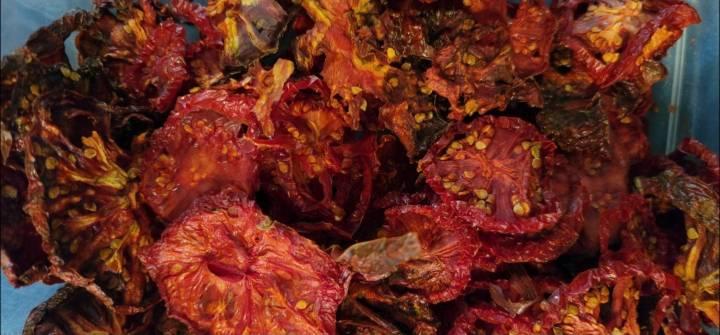 lots of dehydrated tomato slices in various shades of medium to very dark brownish red.