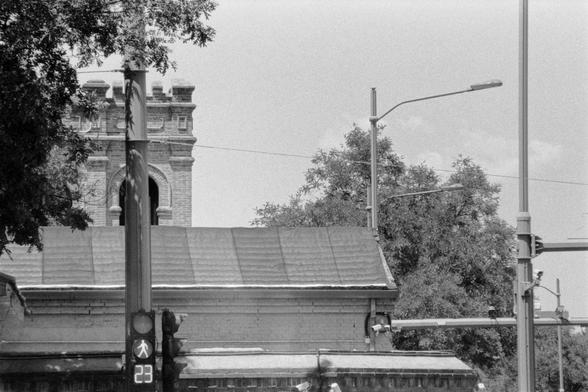 Lucky LUCKY SHD 400 (FF)

English
A black and white photograph of a cityscape. A traffic light is on the left of the picture. Buildings and street lamp posts can be seen on the right side of the picture. Some scattered clouds in the sky, which is well-lit

中文
一张城市的黑白照片.照片中有一个交通灯在左边.照片的中央和右边分别是中国古代建筑和街灯杆.天空中散步着一些云.天空明亮.