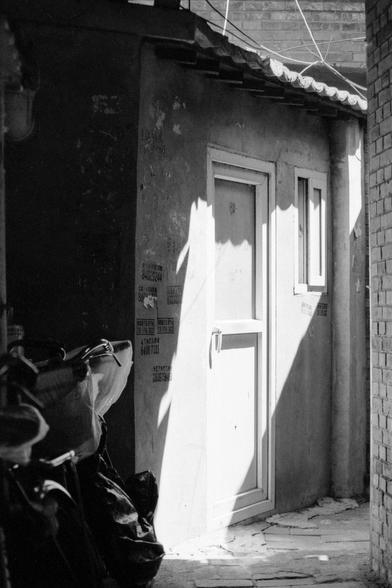 Lucky LUCKY SHD 400 (FF)

English
A black and white photograph of a small alleyway. A motorcycle parks by the side of a wall in the alley. The wall has Chinese calligraphies on it. There is a door and a window on the wall. On the left, a brick wall can be seen.

中文
一张小巷的黑白照片.照片中左侧有一辆摩托车靠在墙边.墙上有中文涂鸦.墙上有一扇窗户和一个门.照片有一堵砖墙.